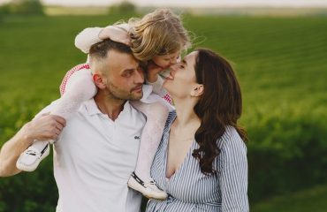 A delightful family moment captured in a lush scenic field, portraying love and happiness.